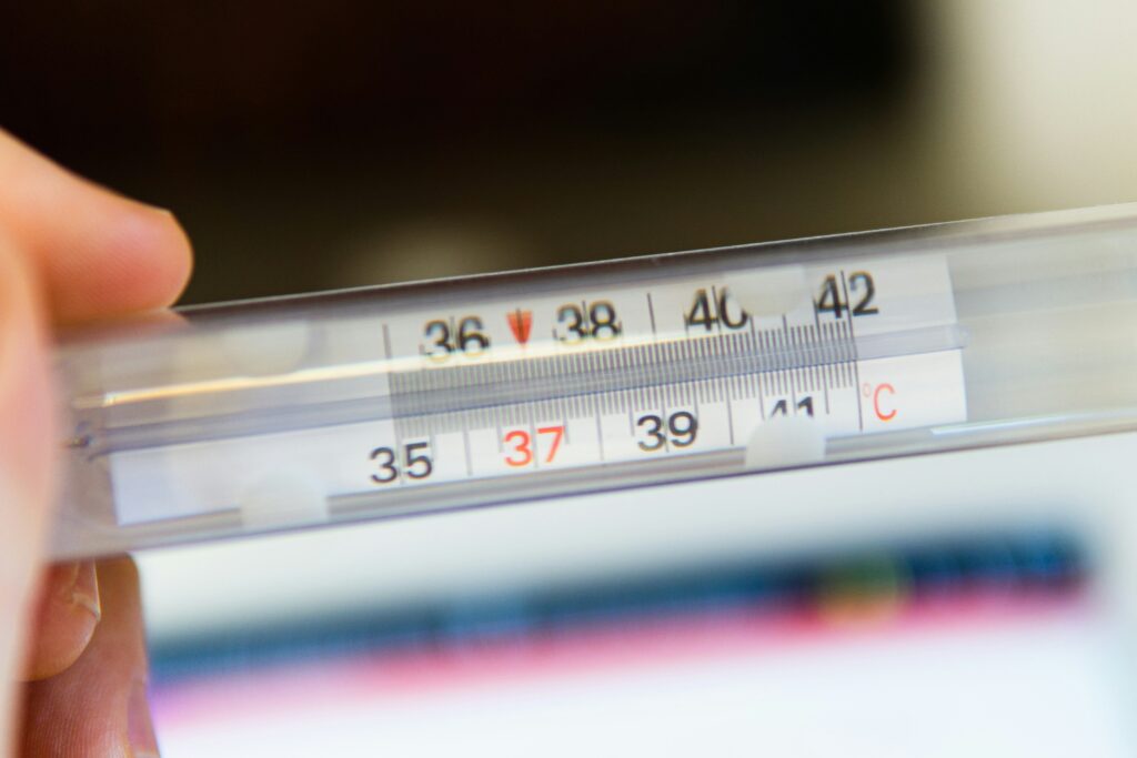 image of a thermometer held by an unseen person.
