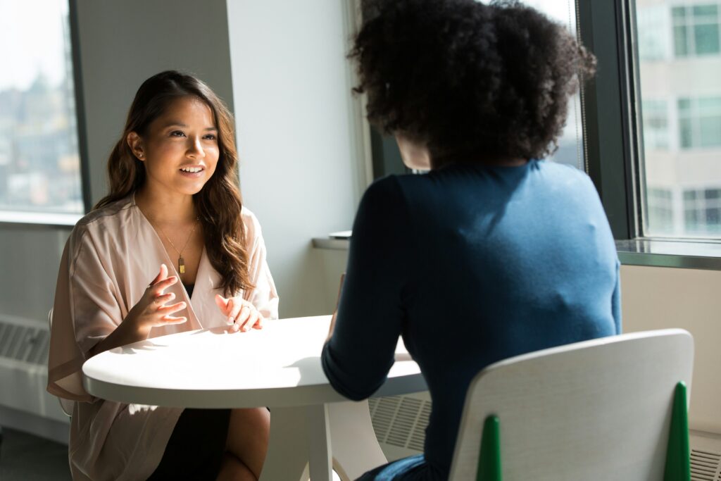 image of two people sitting at a table opposite each other
